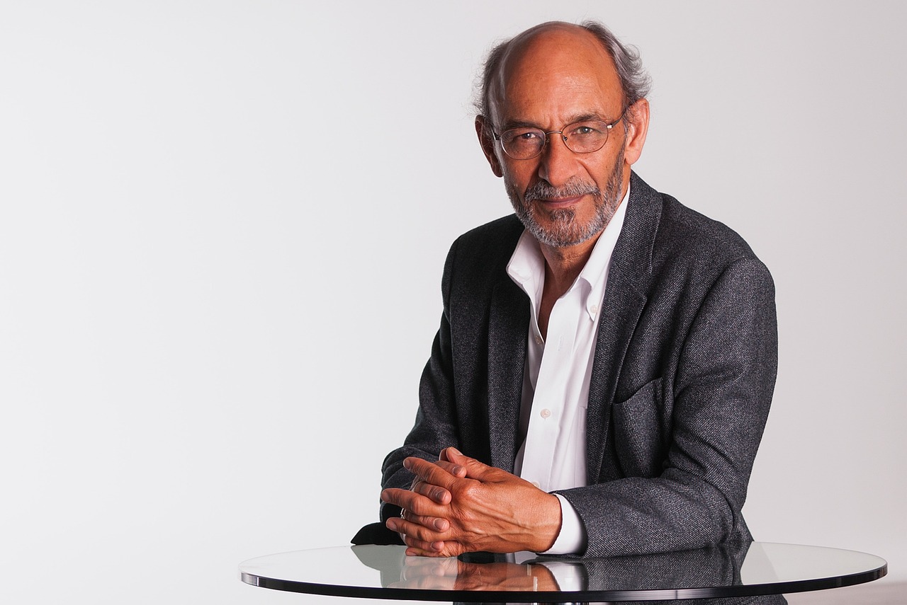 mentor, gray blazer, white shirt, professional, male, corporate portrait, glasses, indian, thin, business executive, consultant, middle-aged, balding, glass table, folding hands, ceo, beard, thinking, ceo, ceo, ceo, ceo, ceo